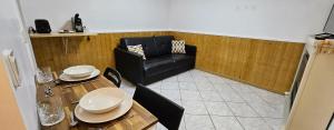 a living room with a table and a black chair at Studio Cozy Paris & Disneyland in Bry-sur-Marne