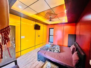 a room with yellow and red walls and a bed at Hotel Dev in Kainūr