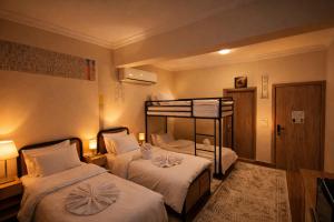 a hotel room with two beds and a bunk bed at The 5 Inn - Rooftop Pyramids View in Cairo