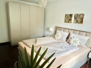 a white bed with white pillows and a plant in a room at Casparidyll in Sigmaringen +47 photos