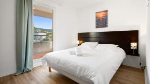 a bedroom with a large white bed with a large window at Virginia N302 - 2p4 in Grasse