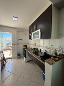 a kitchen with a sink and a stove at Apartamento Elizabetta 3, pé na areia in Arraial do Cabo