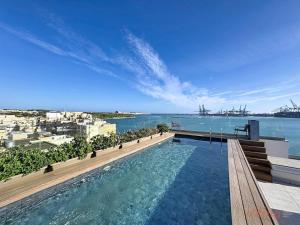 a swimming pool on top of a building with the water at South 32 Hotel by Zzzing in Birżebbuġa