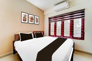 a bedroom with a large bed and a window at Collection O Kottayam Formerly Sap Inn in Kottayam +55 photos