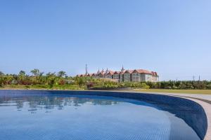 a large swimming pool in front of a house at Radisson Resort & Spa Sasan Gir in Junagadh