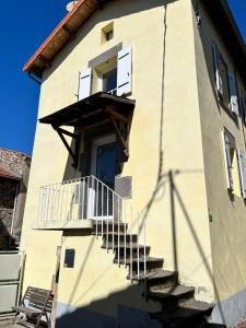 a building with a staircase leading up to a door at Maison de village in Collanges