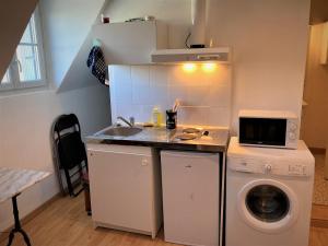 a small kitchen with a sink and a washing machine at Studio double dans l'hypercentre de Limoges in Limoges +3 photos