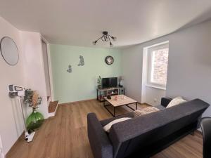 a living room with a couch and a table at Maison de village in Collanges