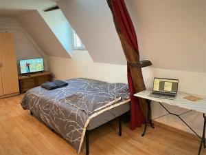 a bedroom with a bed and a laptop on a table at Studio double dans l'hypercentre de Limoges in Limoges