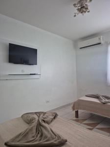 a living room with a tv on a white wall at Casa Baraúnas 05 in Gravatá