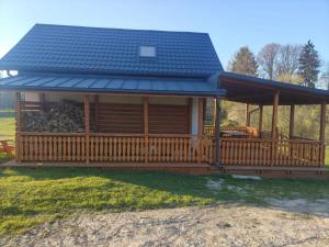 a large wooden cabin with a large deck at Zakątek Sądrecko in Rząśnik
