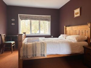 a bedroom with a large bed and a window at Kindrogan House in Straloch