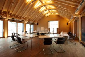a conference room with tables and chairs and a screen at Romantik Hotel Das Lindner in Bad Aibling