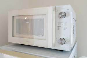 a microwave oven sitting on top of a shelf at Coto House Kamakura RoomA in Kamakura