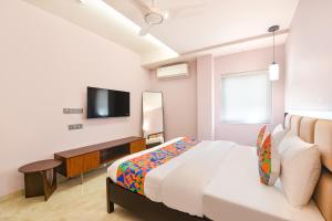 a bedroom with a bed and a tv on the wall at FabHotel The White Cliff Inn - Near Max Hospital Saket in New Delhi