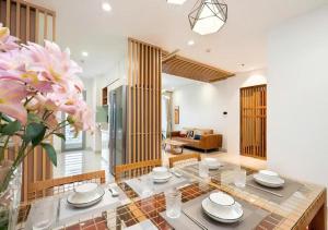 a dining room with a glass table and flowers at Landmark City View - Apartment in Ho Chi Minh City
