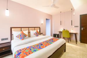 a bedroom with a large bed and a desk at FabHotel The White Cliff Inn - Near Max Hospital Saket in New Delhi