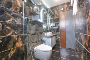 a bathroom with a toilet and a sink at FabHotel The White Cliff Inn - Near Max Hospital Saket in New Delhi +27 photos