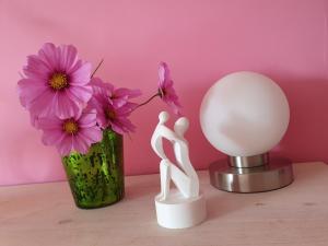 a couple figurine next to a vase of flowers at Zimmer an der Wedel in Burgwedel