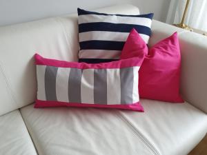 a white couch with three pillows on it at Zimmer an der Wedel in Burgwedel