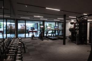 a gym with a lot of exercise equipment and windows at SomVita Suites in Tirolo