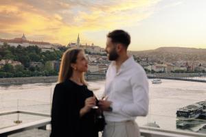 a man and a woman standing on a bridge overlooking the river at Budapest Marriott Hotel in Budapest
