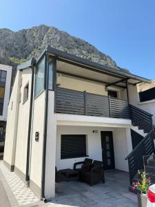 a house with a balcony with a mountain in the background at Olive Depadance in Mostar