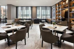 a restaurant with tables and chairs and windows at AC Hotel by Marriott Ann Arbor Downtown in Ann Arbor