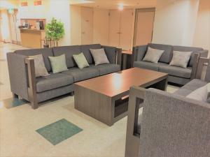 a living room with two couches and a coffee table at Hotel Crown Hills Yamagata in Yamagata