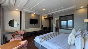 a bedroom with a bed and a table and a tv at Emroz Kings Resort in Batakūt