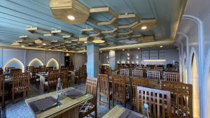 a dining room with wooden tables and chairs at Emroz Kings Resort in Batakūt