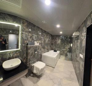 a bathroom with a sink and a toilet and a shower at Emroz Kings Resort in Batakūt +7 photos