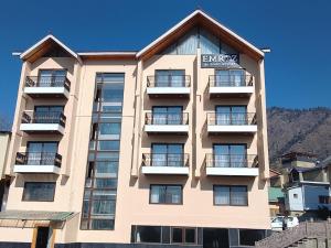 a large building with balconies on the side of it at Emroz Kings Resort in Batakūt