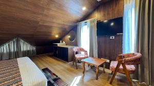a bedroom with a bed and a table and chairs at Emroz Kings Resort in Batakūt