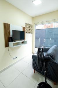 a living room with a couch and a tv at Studio Funcional c Wifi perto do Centro Itabuna in Itabuna