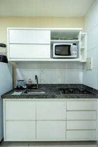 a kitchen with a sink and a microwave at Studio Funcional c Wifi perto do Centro Itabuna in Itabuna