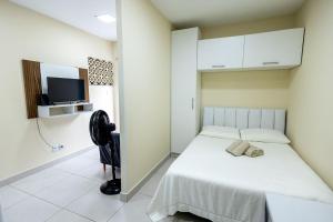 a bedroom with a bed and a flat screen tv at Studio Funcional c Wifi perto do Centro Itabuna in Itabuna