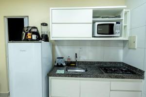 a small kitchen with a sink and a microwave at Studio Funcional c Wifi perto do Centro Itabuna in Itabuna +4 photos
