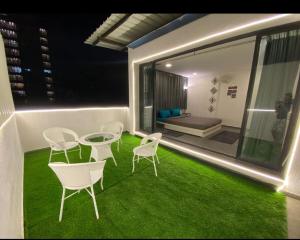 a balcony with a table and chairs on the grass at Sunleaf Palace in Pune