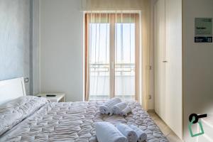 a bedroom with a bed with towels on it at Hotiday Gallipoli Lungomare in Gallipoli