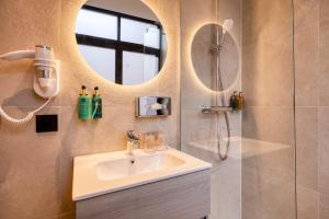 a bathroom with a sink and a shower with a mirror at ALMA Grand Place Hotel in Brussels