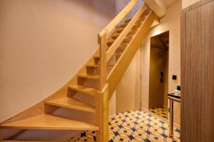 a wooden staircase in a house with a tile floor at ALMA Grand Place Hotel in Brussels
