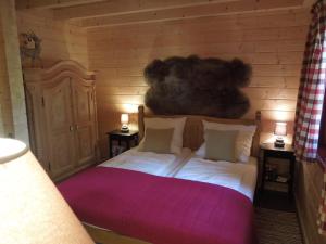 ブラウンラーゲにあるBlockhaus Bodefallの木製の部屋に大型ベッドが備わるベッドルーム1室が備わります。