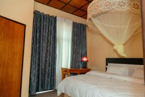 a bedroom with a bed and a window with curtains at Kibeho Pilgrimage Center in Giseke