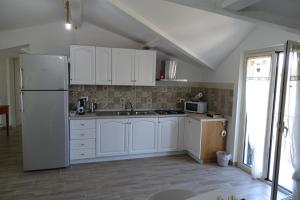 a kitchen with white cabinets and a white refrigerator at MaMo B&B in Nocera Terinese