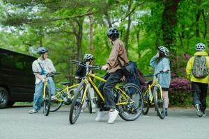 a group of people with their bikes on a street at Vacation House Kawaraya in Senboku