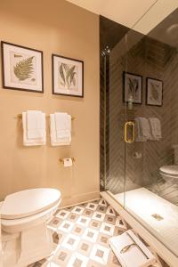 a bathroom with a toilet and a shower at Sinclair Suites - Boutique Hotel West Dundee in West Dundee