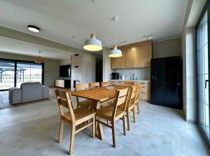 a kitchen and dining room with a wooden table and chairs at FORESTA in Redliny