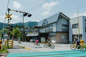 a group of people riding bikes down a street at Vacation House Kawaraya in Senboku
