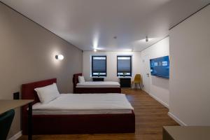 ein Zimmer mit zwei Betten und zwei Fenstern in der Unterkunft N17 Hotel in Poltawa